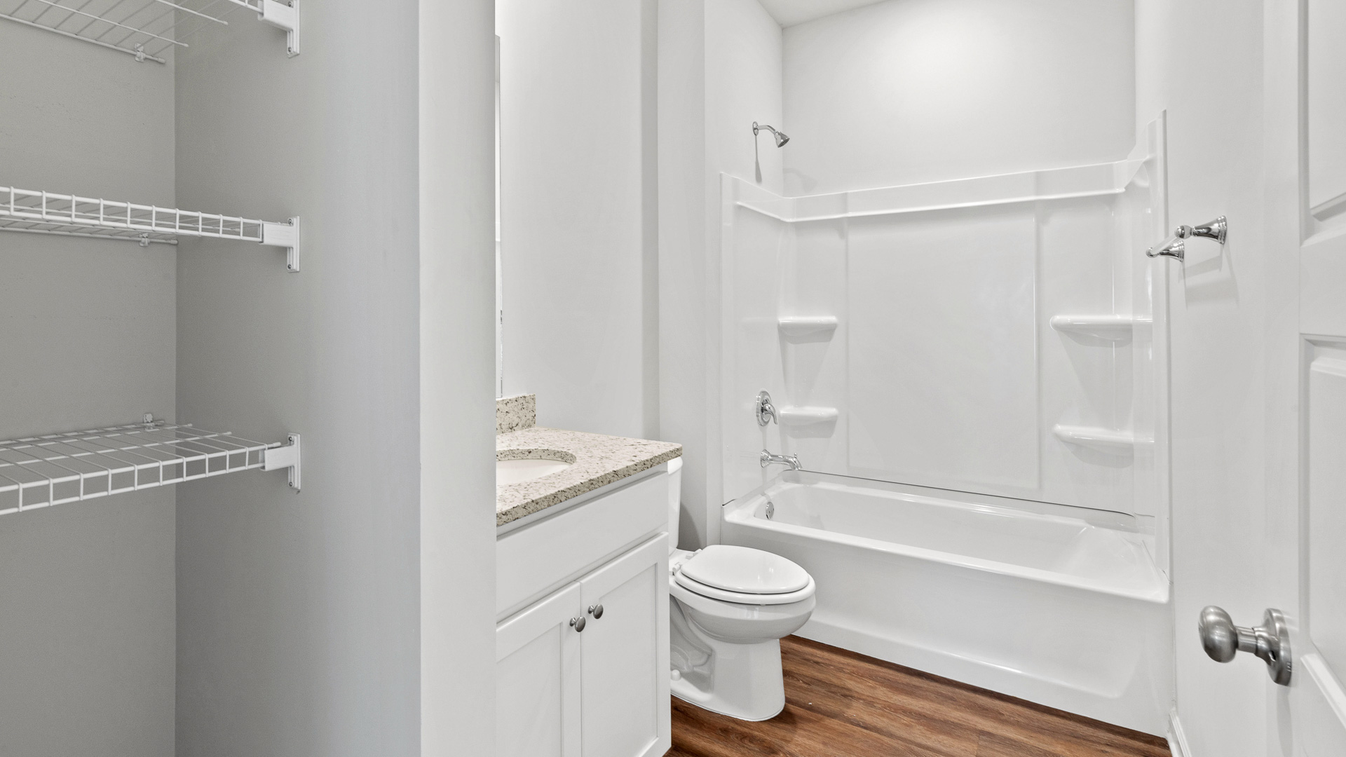 bathroom featuring a vanity sink, toilet, bathtub and built in shelves