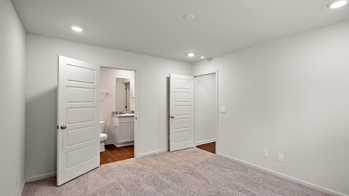 Other side of bedroom with attached bathroom and entry door.