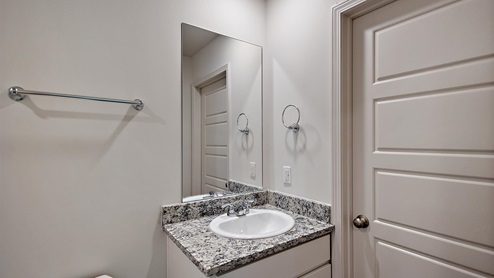 Bathroom with single sink light gray granite vanity.