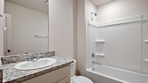 Bathroom with single sink light gray granite vanity with a shower and tb combined.