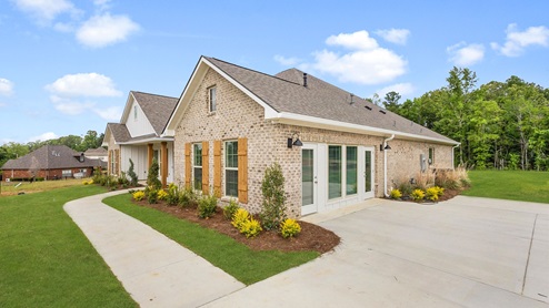 Exterior beige home with stone detailing and driveway
