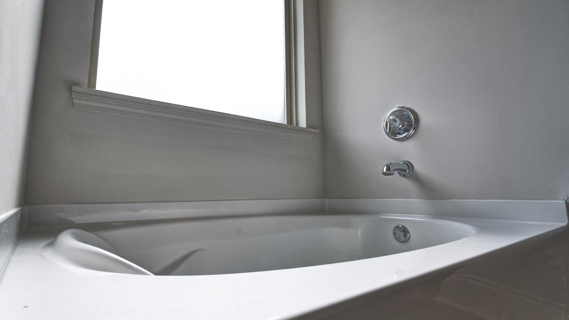 interior bathroom tub with large frosted window