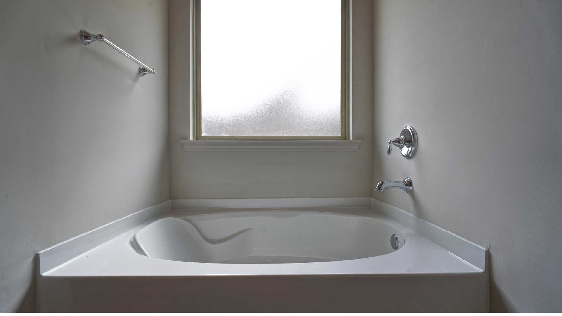 interior bathroom tub with large frosted window