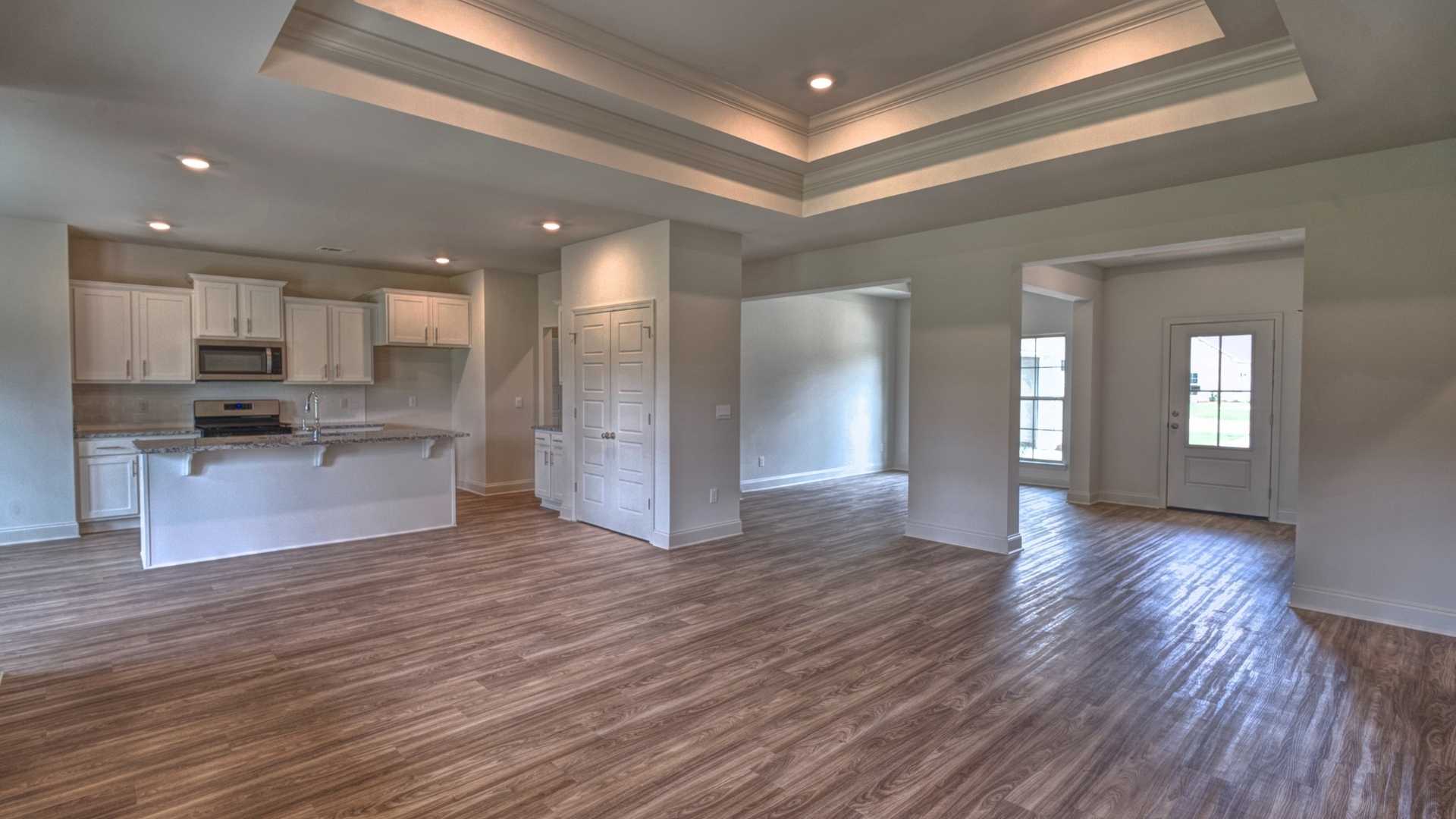 Interior living room with coffered ceilings open to kitchen