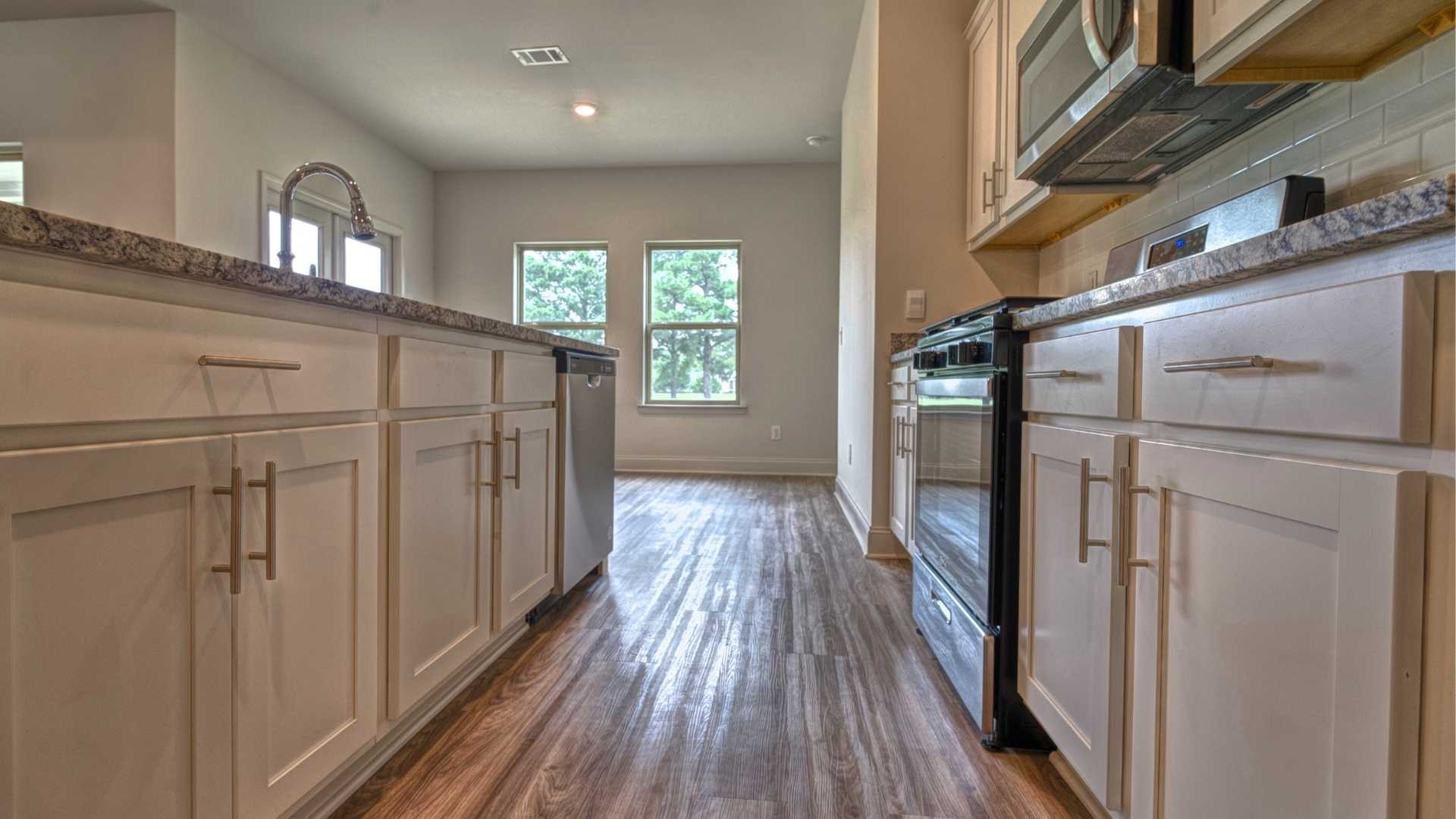 interior kitchen with white cabinets next to breakfast area