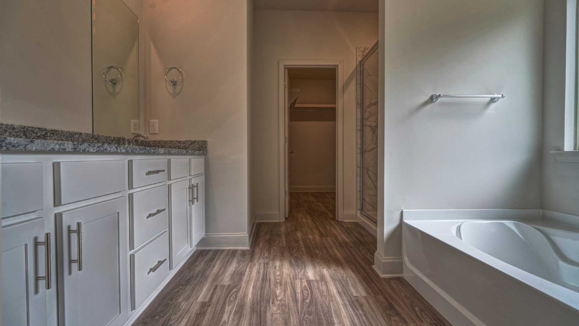 interior bathroom with double vanity and walk in shower and bathtub