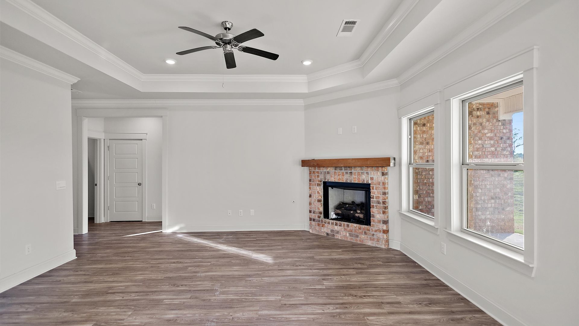 View from kitchen into the dining and living rooms, backyard area with outdoor access to patio at Cornerstone