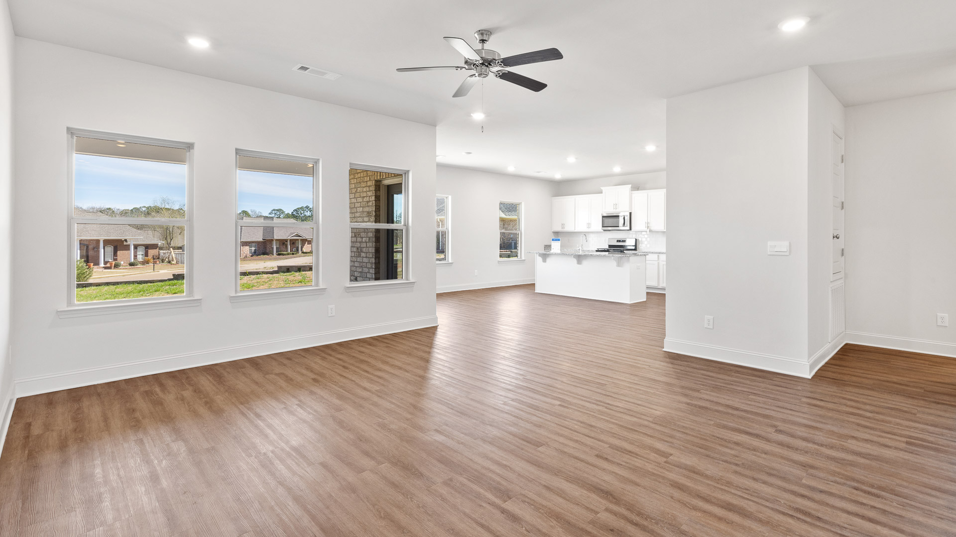 Open concept living room with several windows for natural lighting.