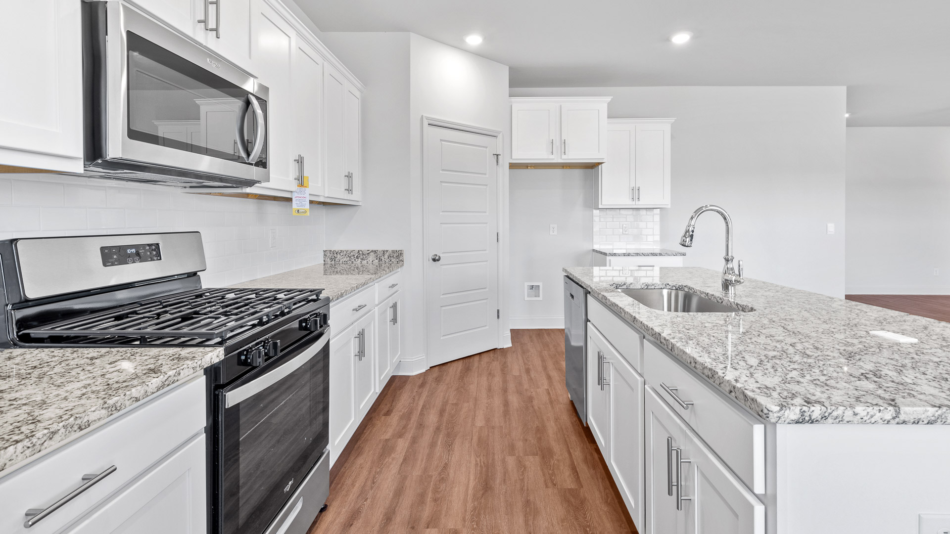 Kitchen with stainless steel appliances and white tile backsplash.