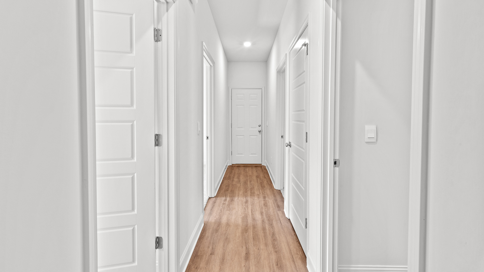 Hallway between bedrooms with extra storage closet and bathroom nearby.