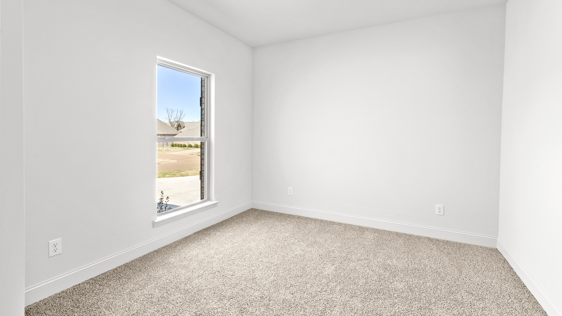 Bedroom with carpeted floor and single long window for lighting.