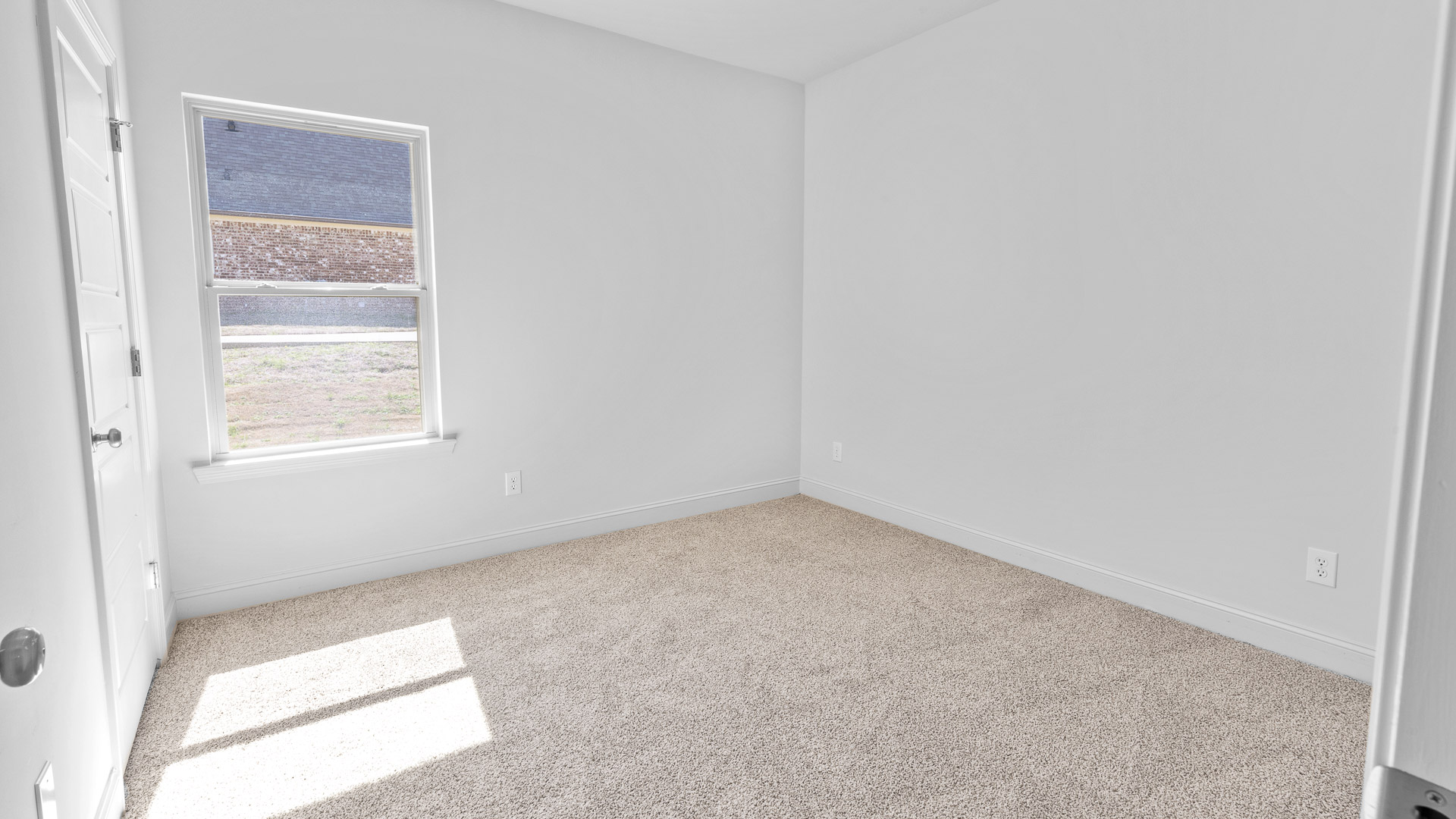 Bedroom with carpeted floors and several outlets.