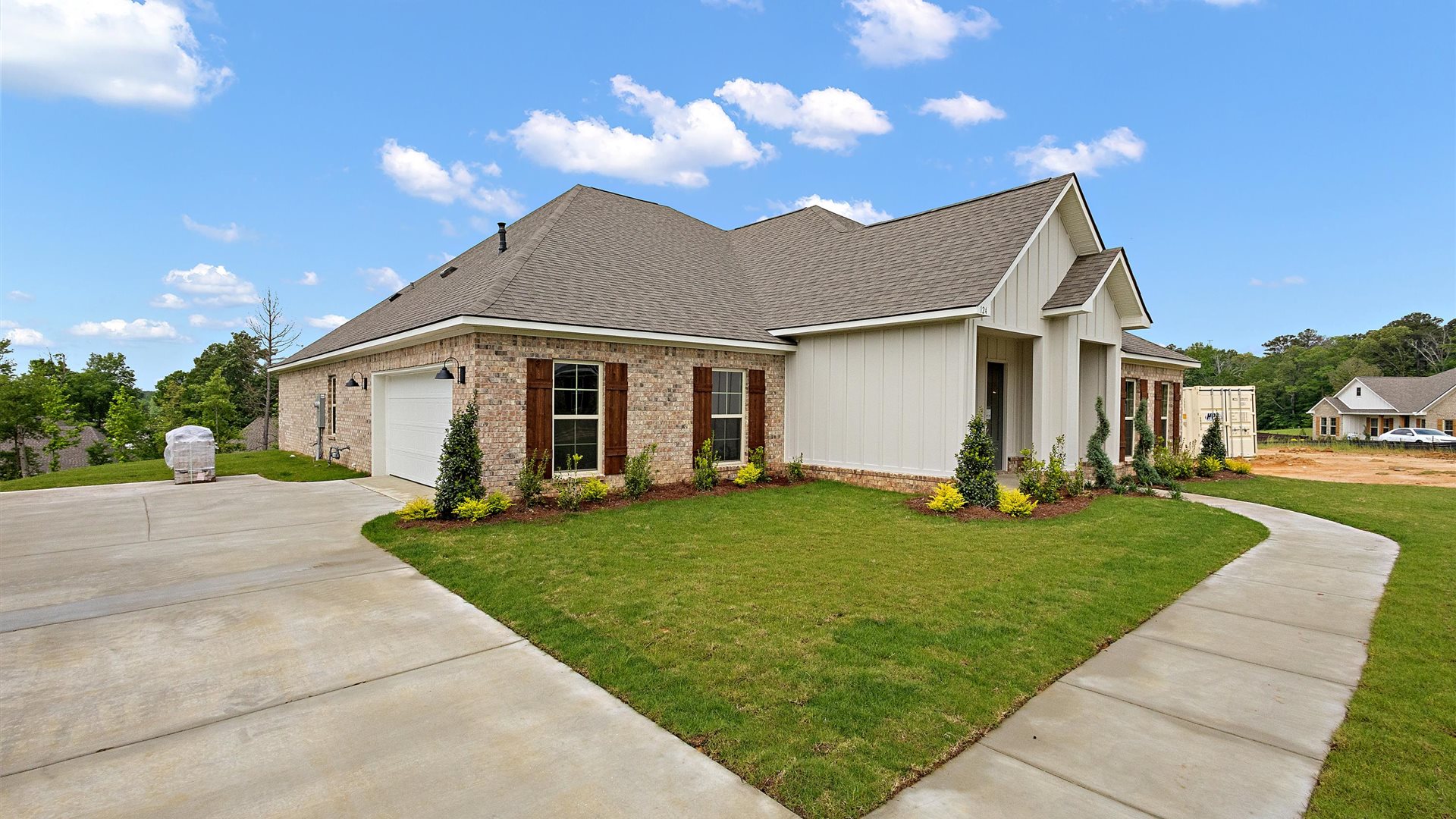 Side view of the exterior of the home featuring a driveway and a garage
