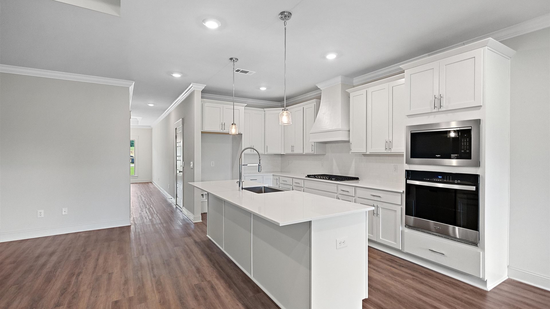 beautiful spacious kitchen featuring white cabinetry, large island and stainless steel appliances