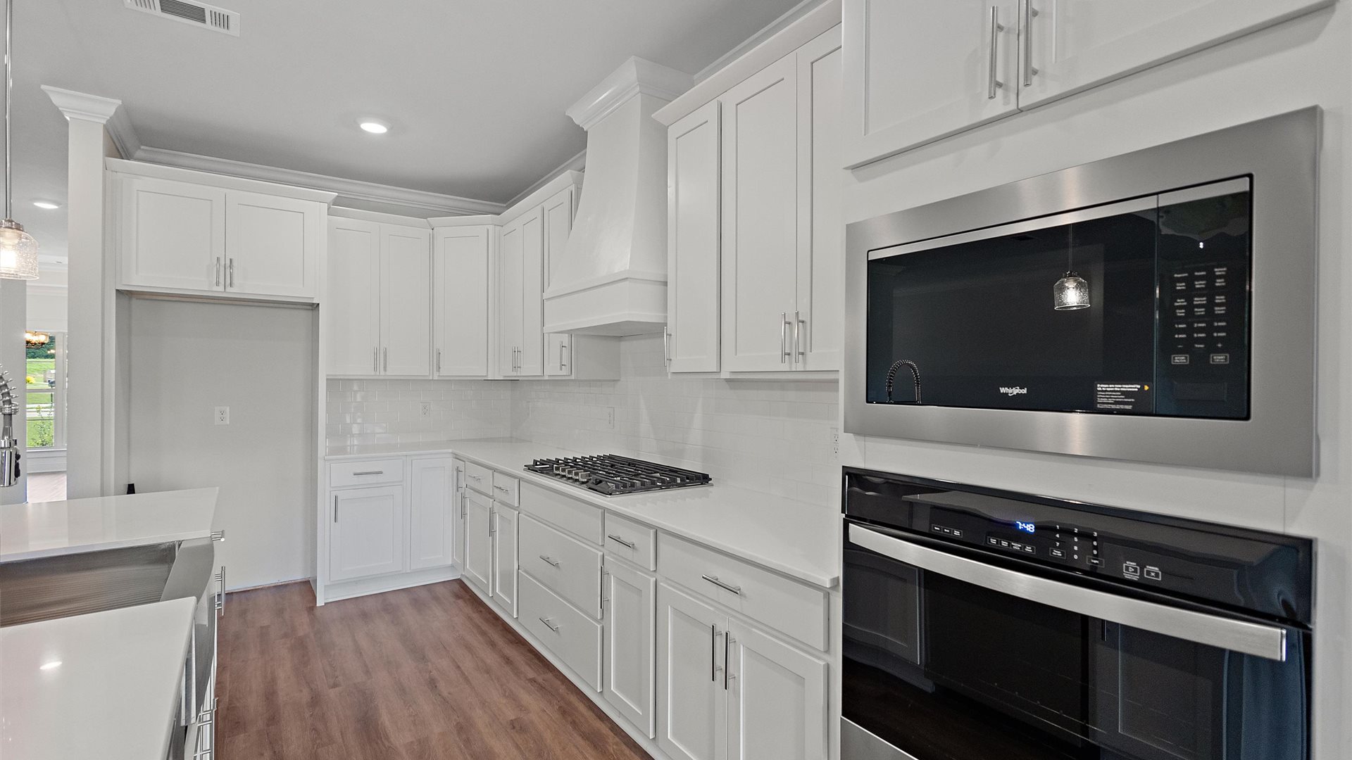 beautiful spacious kitchen featuring white cabinetry, large island and stainless steel appliances