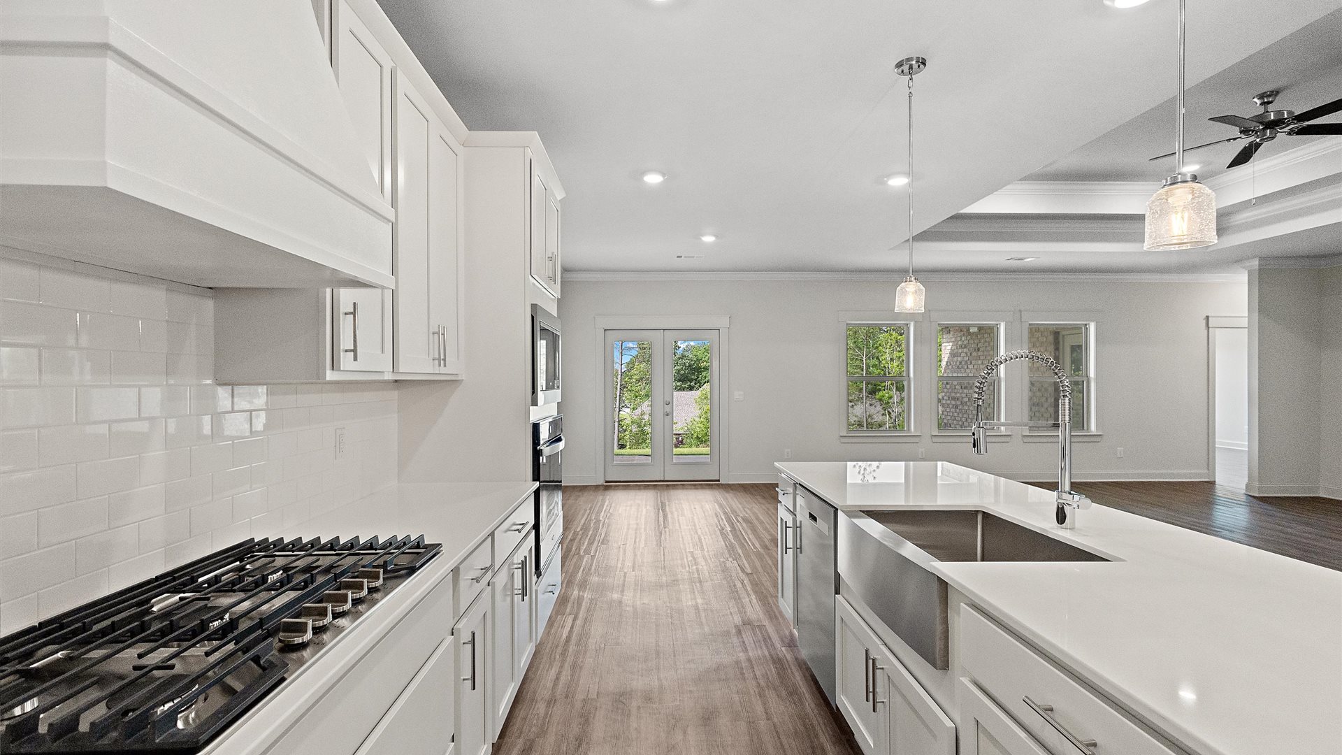 beautiful spacious kitchen featuring white cabinetry, large island and stainless steel appliances