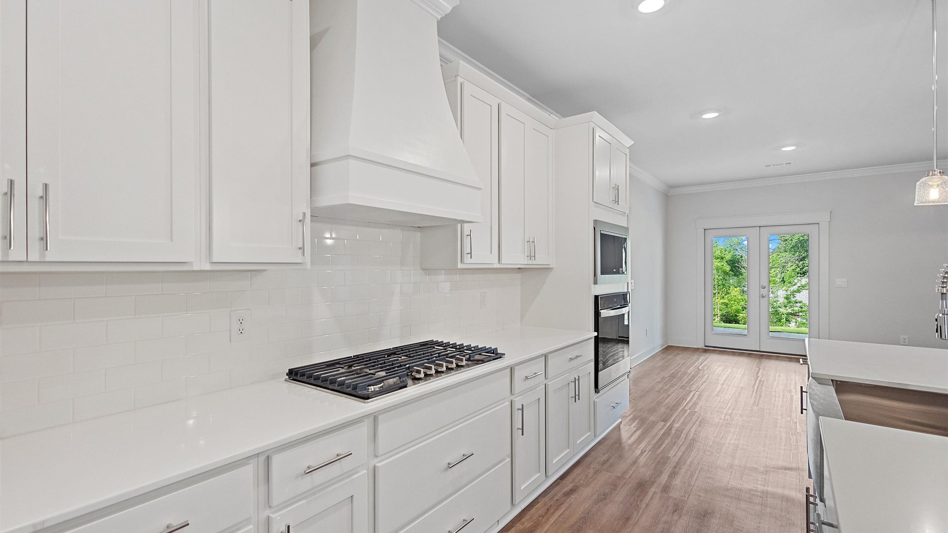 beautiful spacious kitchen featuring white cabinetry, large island and stainless steel appliances