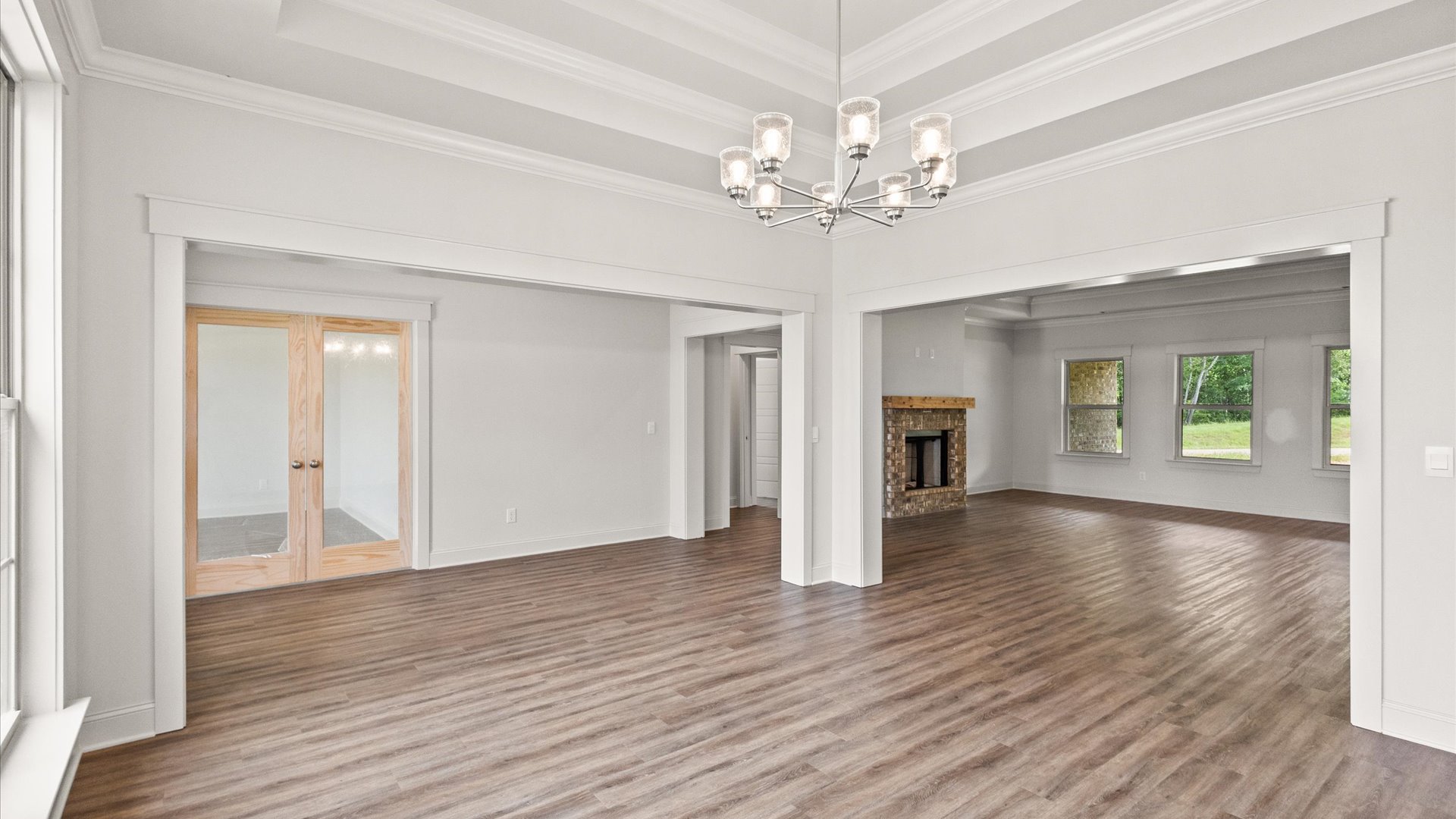 Interior dinning area open to living room with chandelier