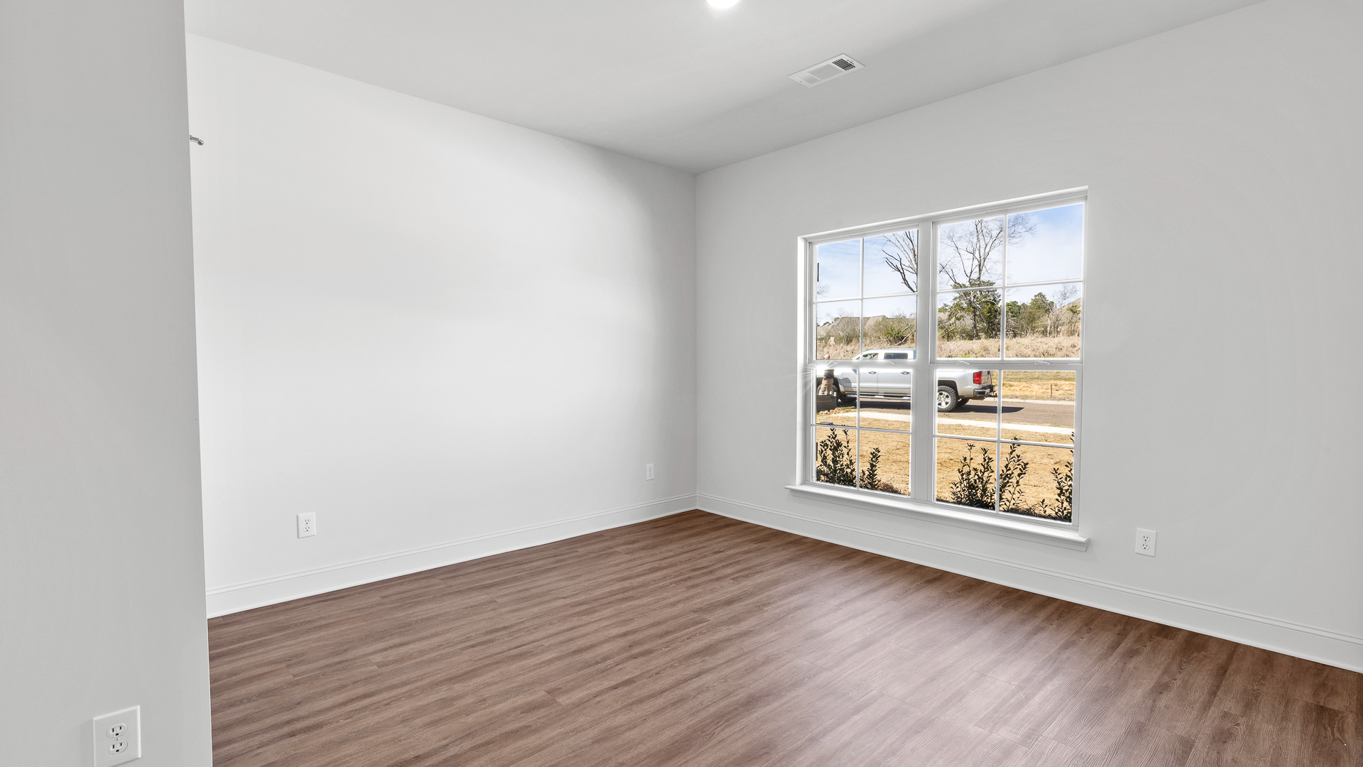 bedroom with hardwood floors, recessed lighting, and window