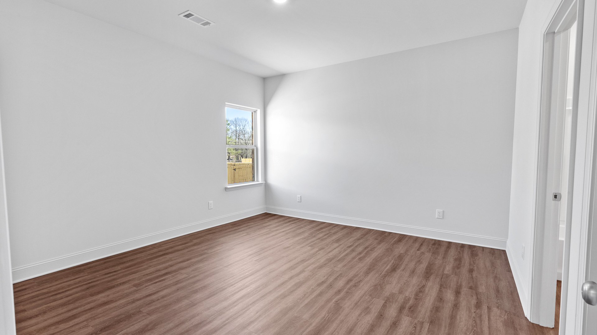 bedroom with hardwood floors, recessed lighting, and window