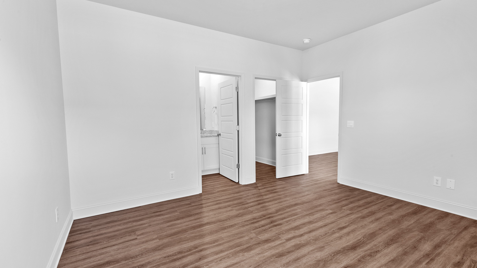 bedroom with hardwood floor and recessed lighting with closet and bathroom