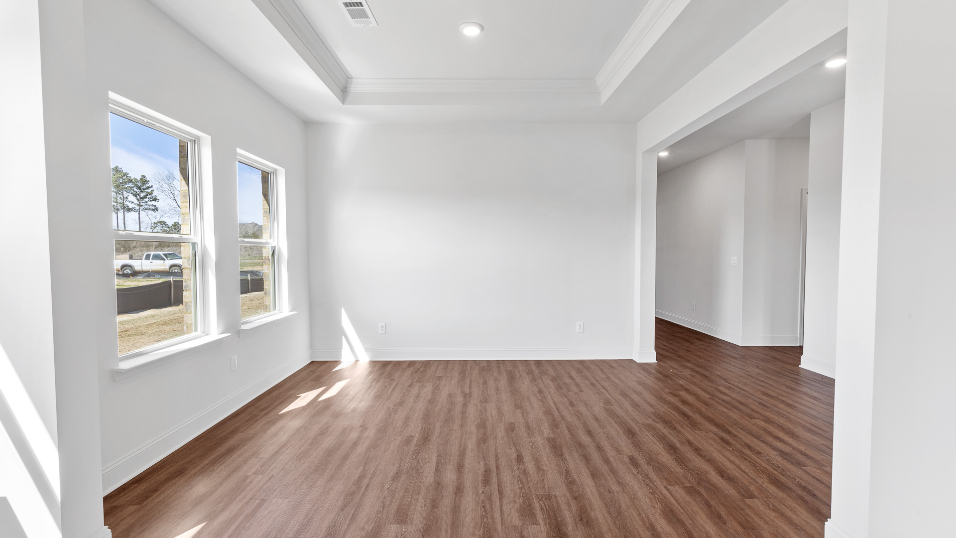 dining room with tray ceilings, hardwood floors, and recessed lighting