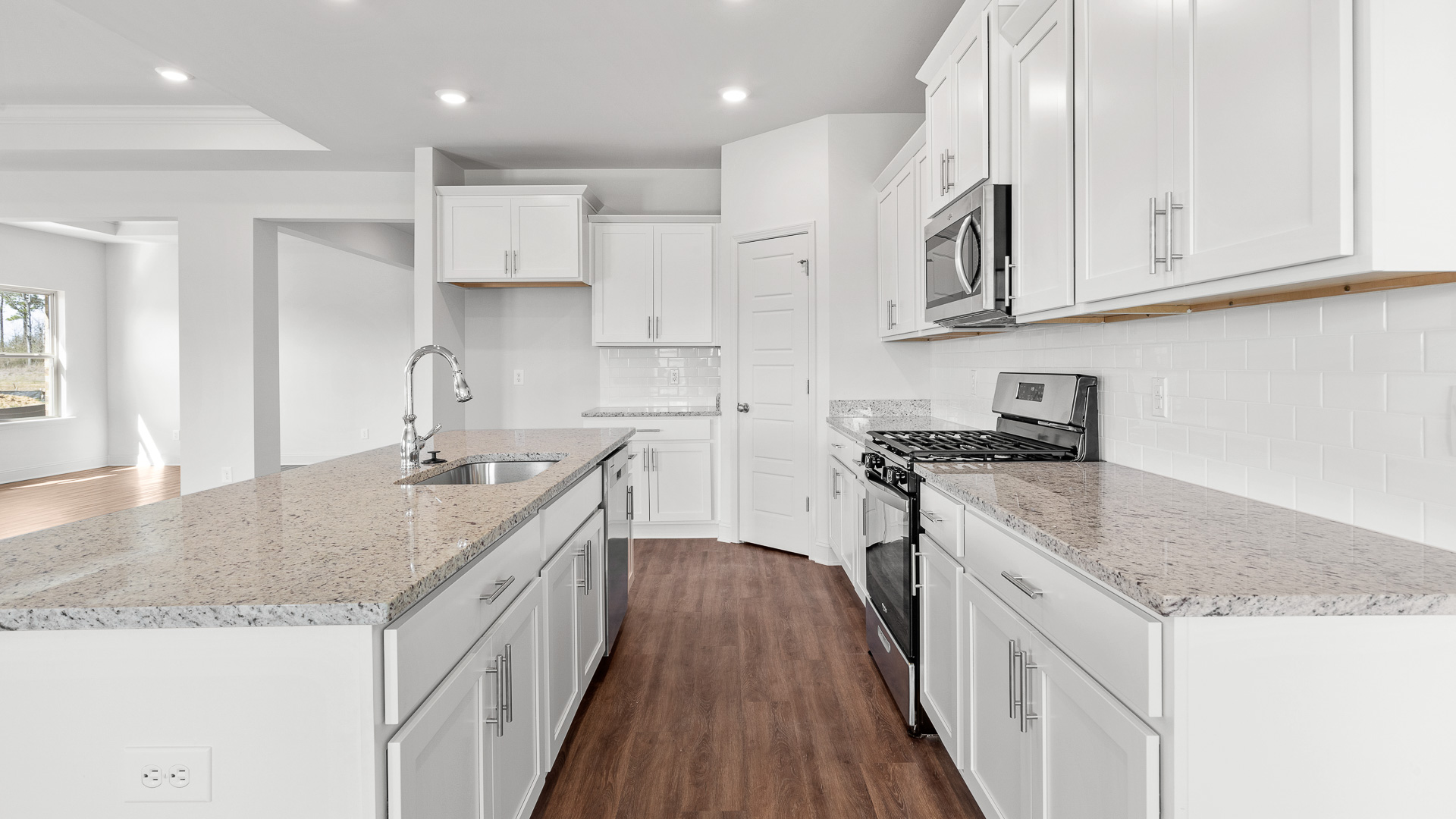 modern kitchen with granite countertops, recessed lighting, stainless steel appliances, and shaker cabinets