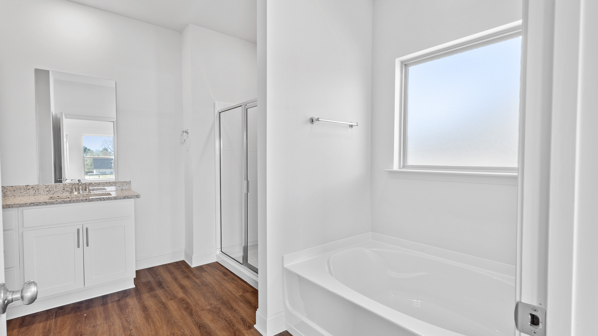 stand-up shower with adjacent garden tup and frosted window overlooking to tub