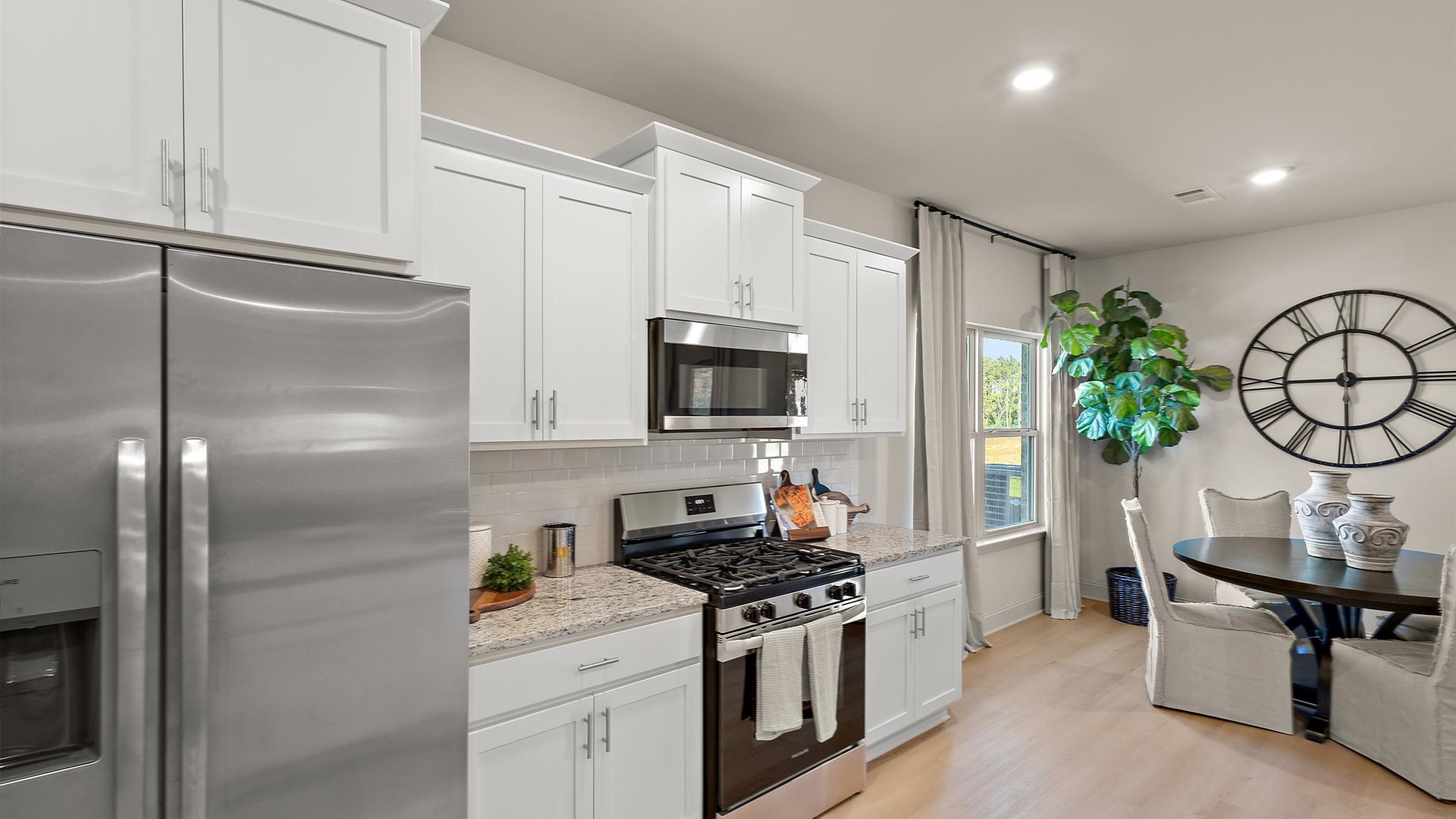Spacious kitchen with granite countertops, island, and stainless-steel appliances.