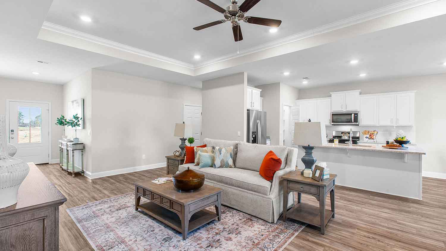 spacious living room featuring a beige sofa, and teal accent chairs