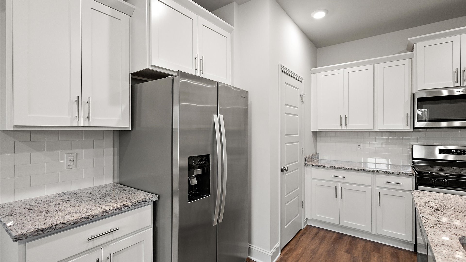 The single-story home plan has a spacious kitchen and island with granite countertops and appliances.