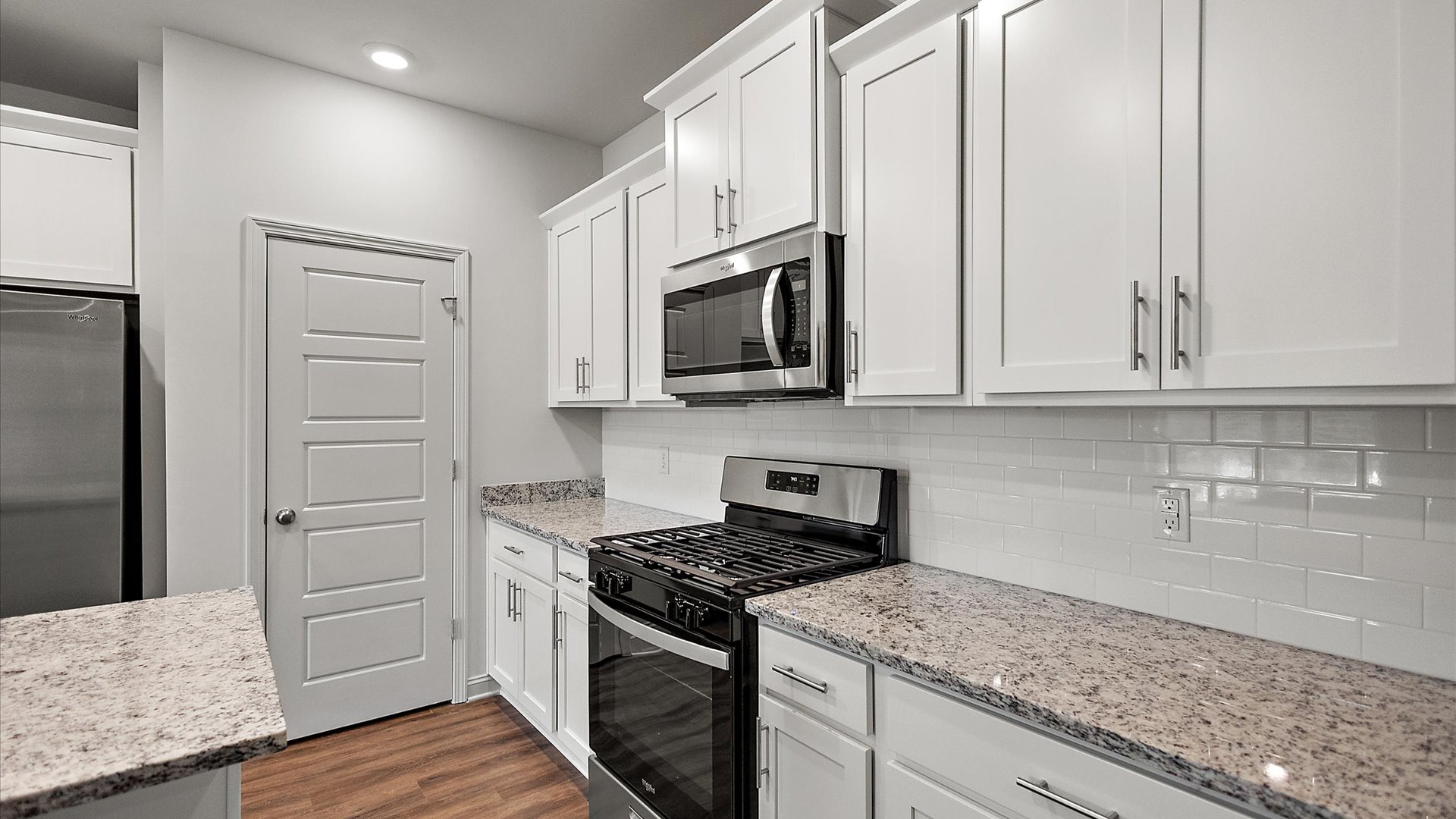 The single-story home plan has a spacious kitchen and island with granite countertops and appliances.