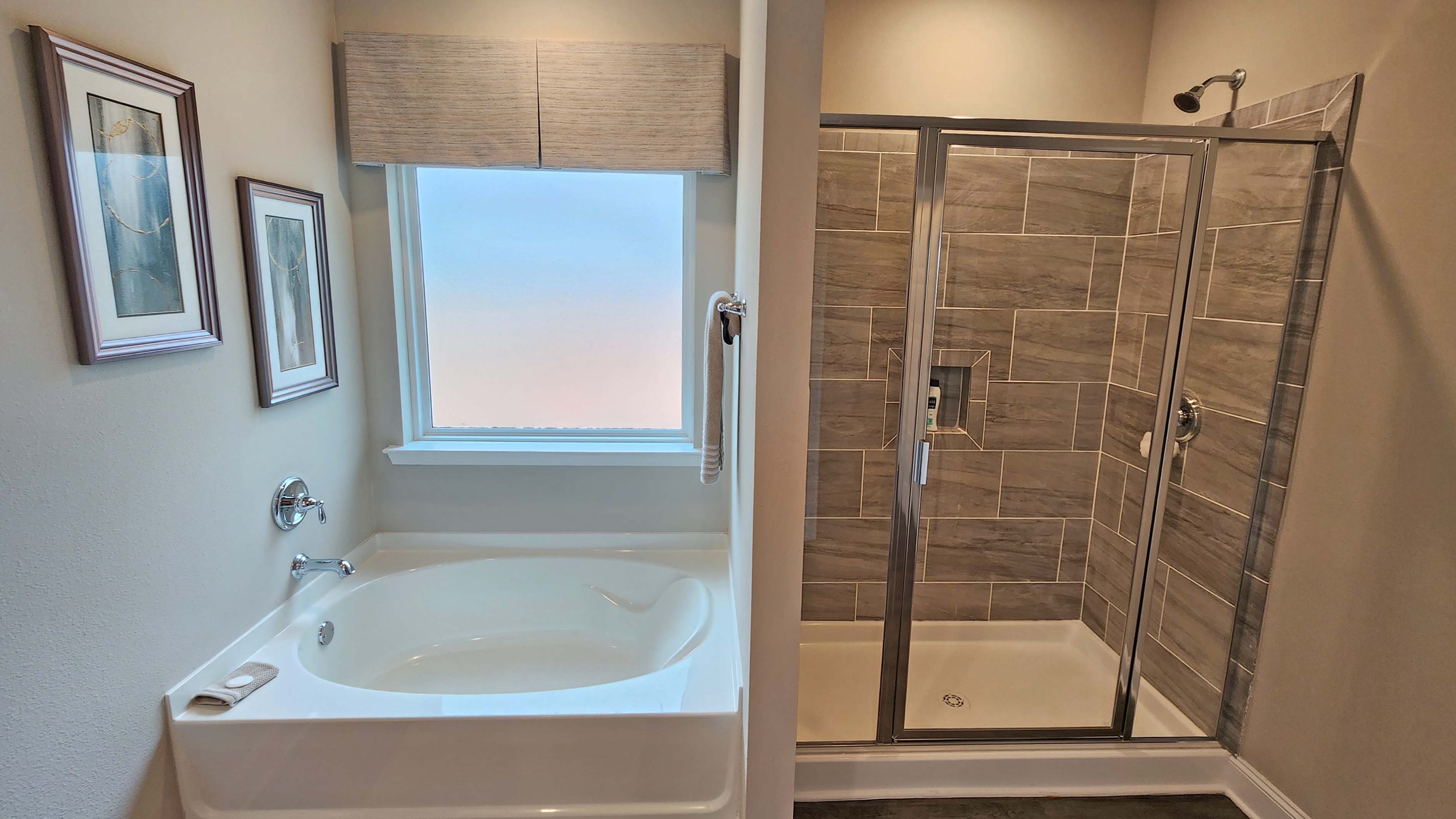 garden tub with frosted window and walk in shower