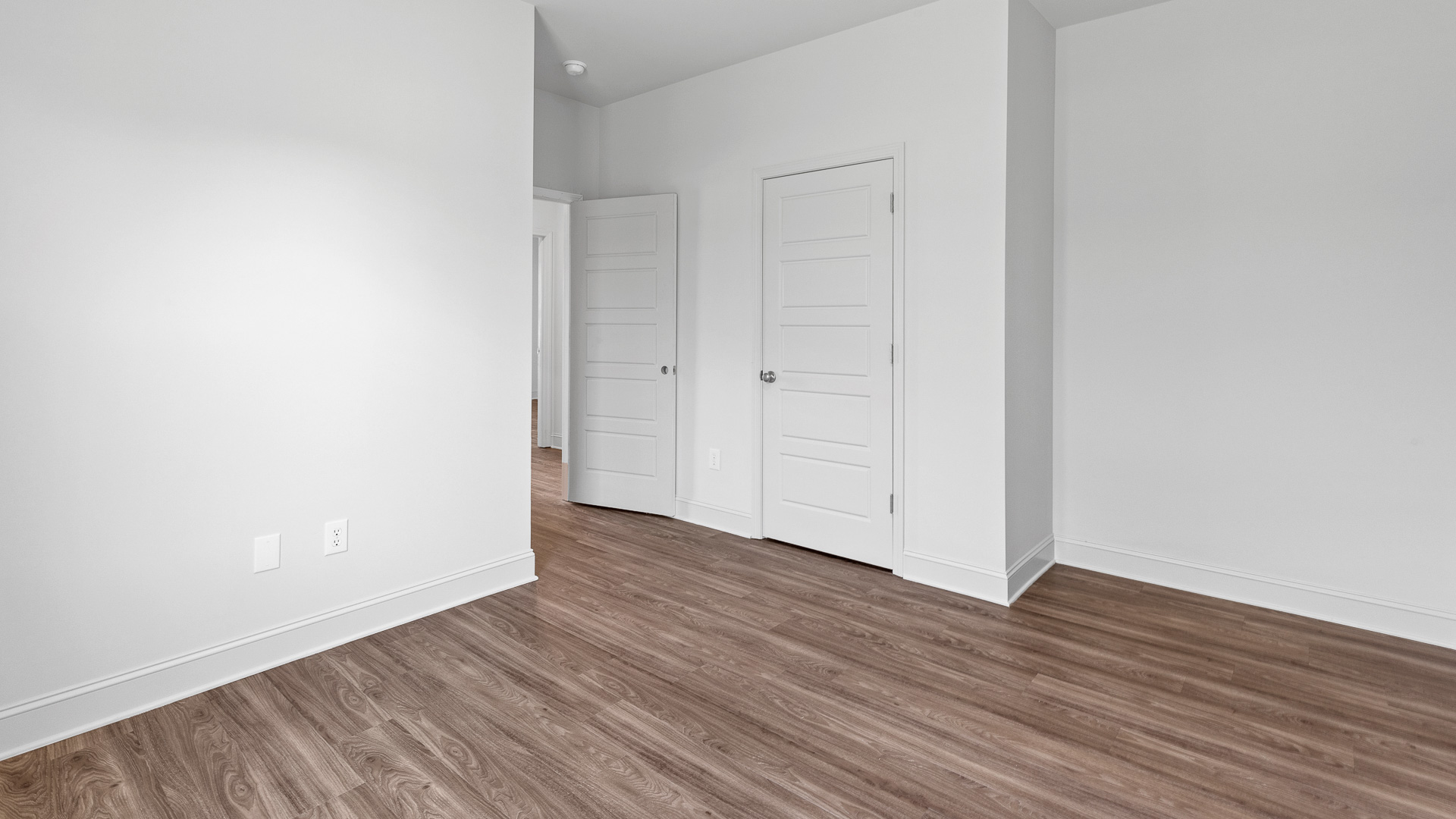 Hall and door to the half bath located in in the open concept living space.