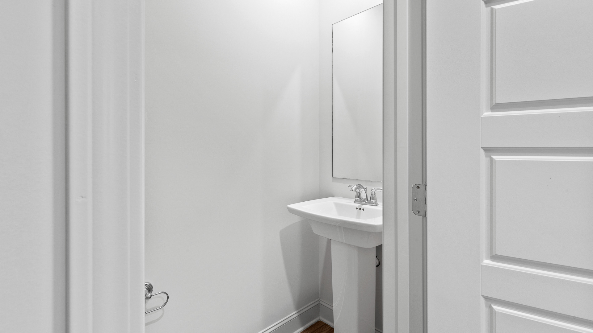 Half bathroom with toilet and sink in the open concept living space.