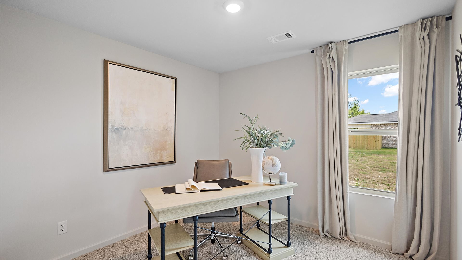 home office with a desk and chair and a window with beige curtains