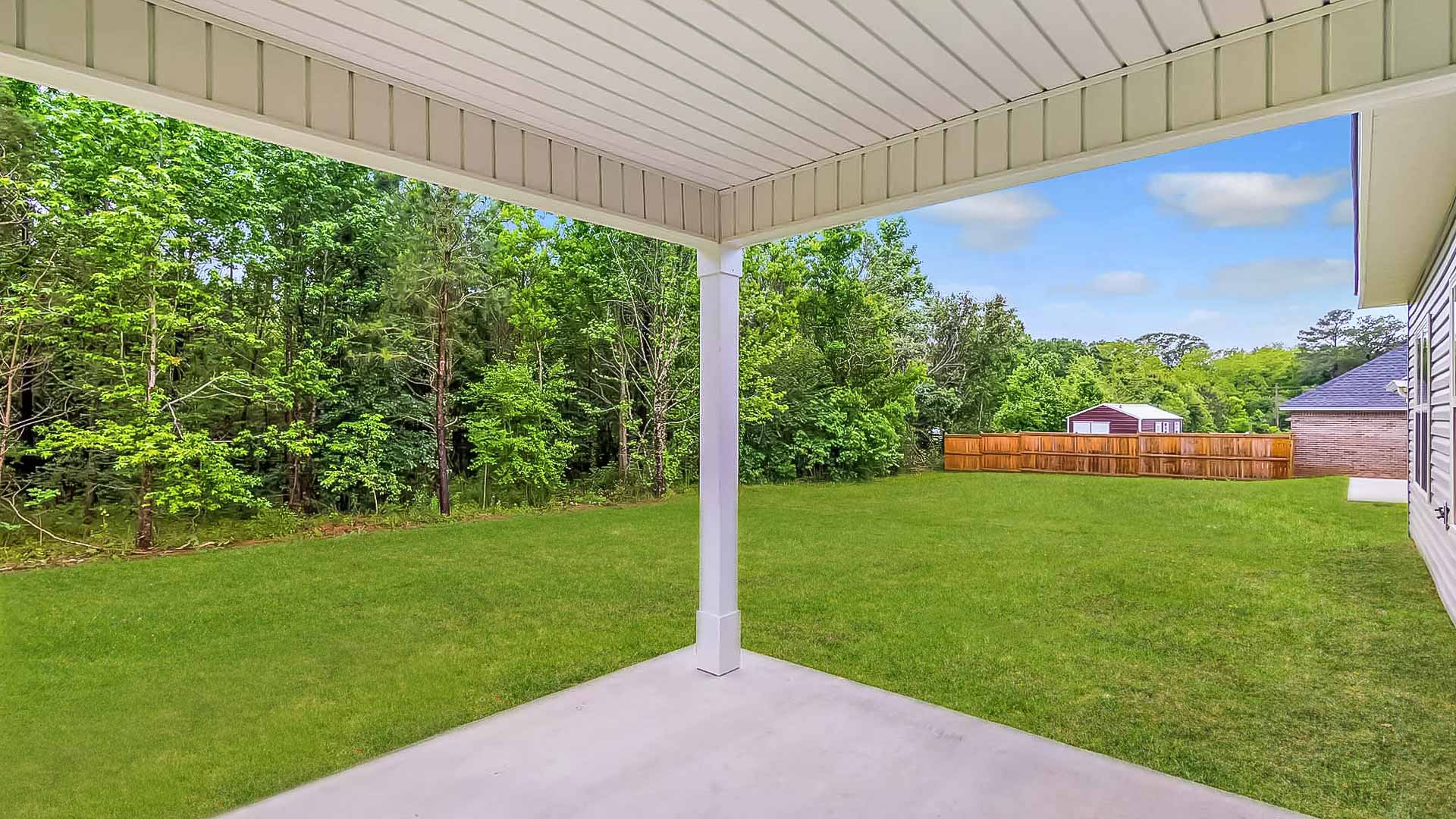 The covered back patio opens to greenspace.