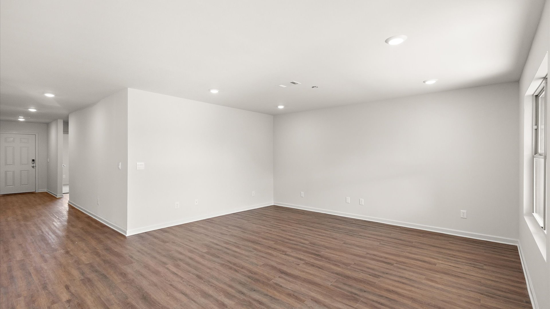 Living space with hardwood floors and recessed lighting