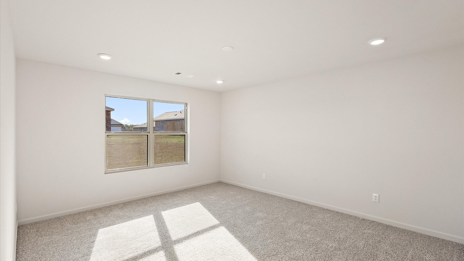 Primary bedroom with carpeted floors and window for natural light