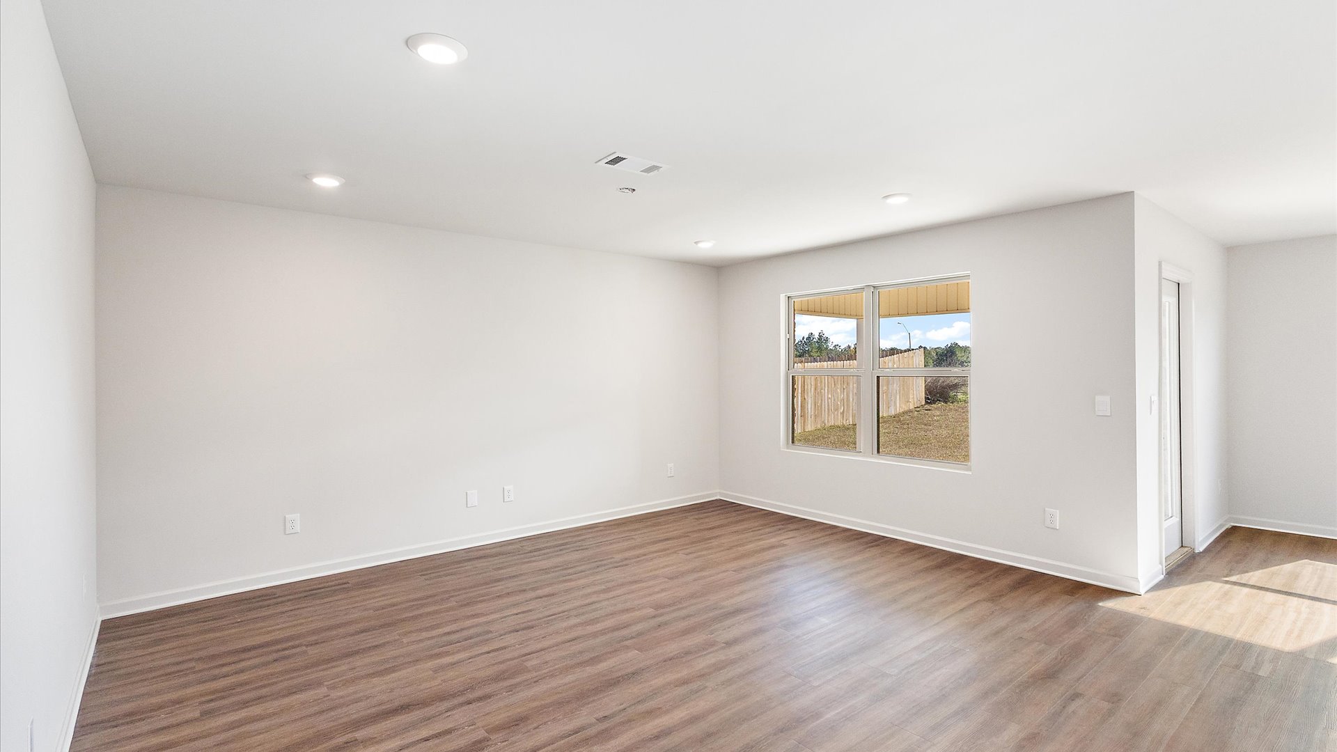 Living space with hardwood floors and recessed lighting