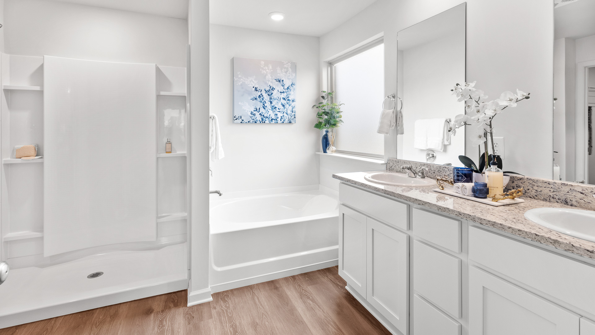 The ensuite bathroom features a walk-in shower, a garden tub, an opaque picture window, a double sink vanity with granite countertops, and white shaker-style cabinets.