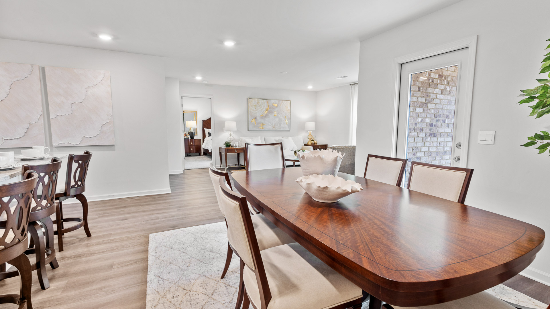 Spacious dining room in front of the kitchen with a glass back door and a view of the living room.