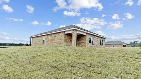 A rear exterior view of the yard and house features a covered back porch.