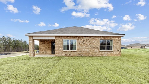 A rear exterior view of the house features a covered back porch and two double windows.