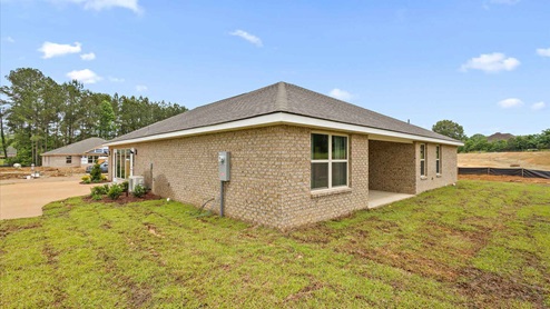 Back side exterior of the covered patio and other side of the house where the drive way is located.