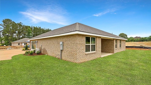 Back side exterior of the covered patio and other side of the house where the drive way is located.