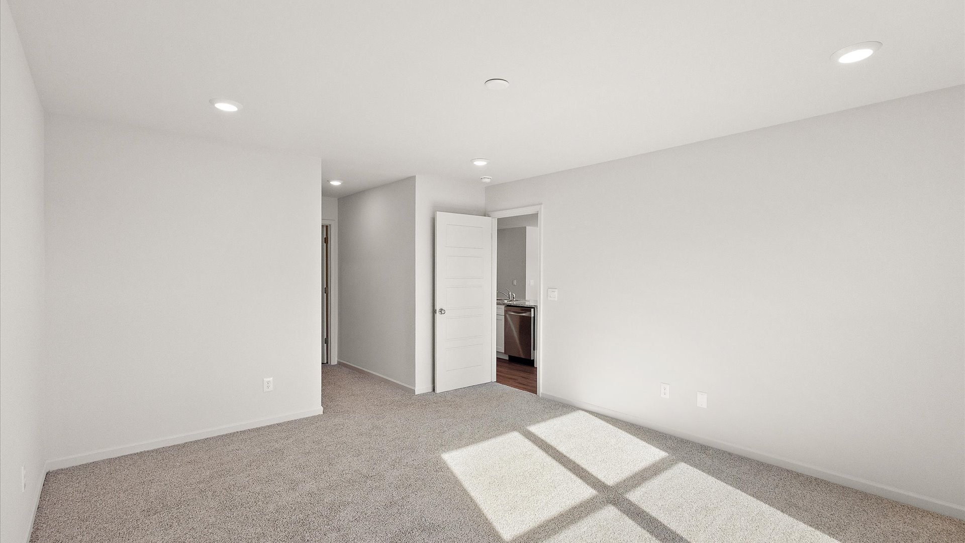 Primary bedroom with carpeted floors and recessed lighting