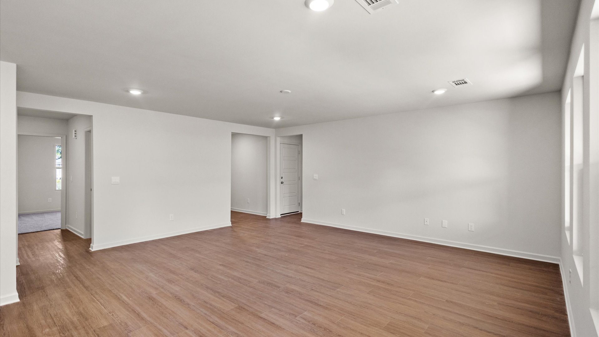 spacious living area with hardwood floors and recessed lighting