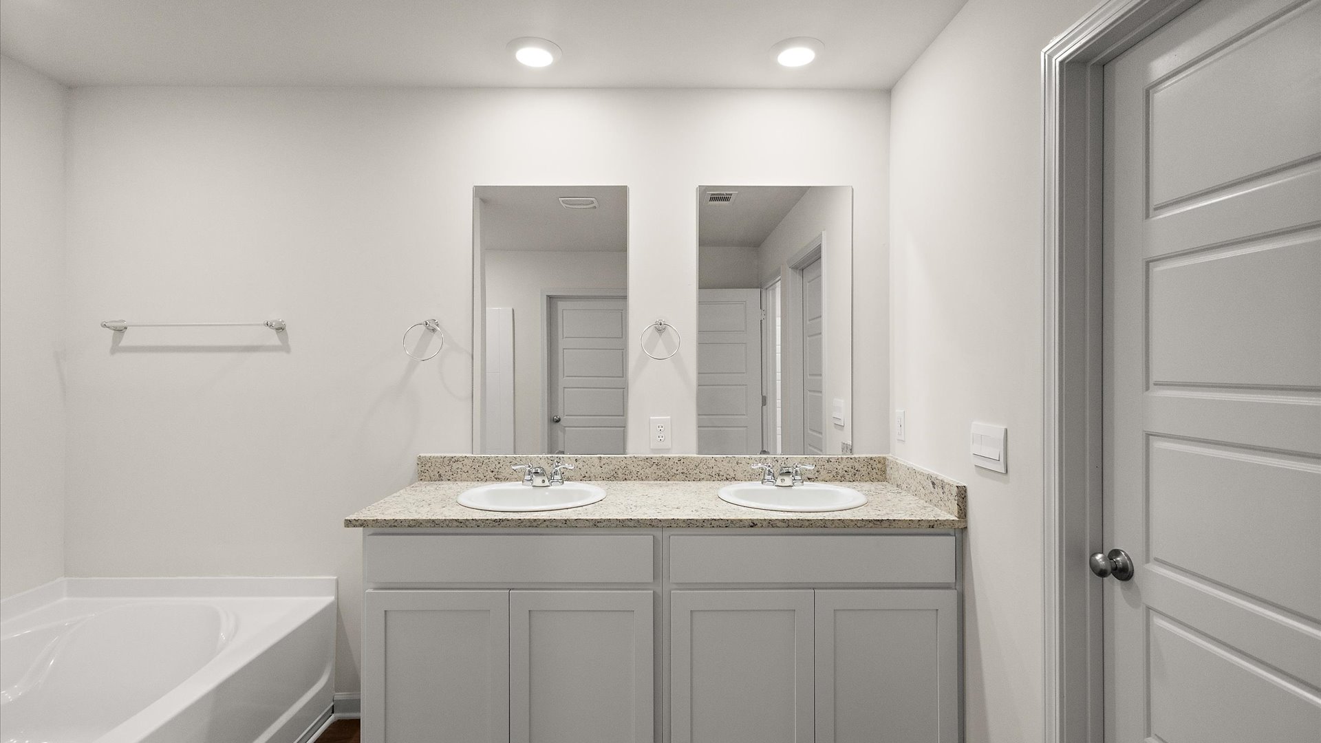 dual vanity with recessed lighting and garden tub
