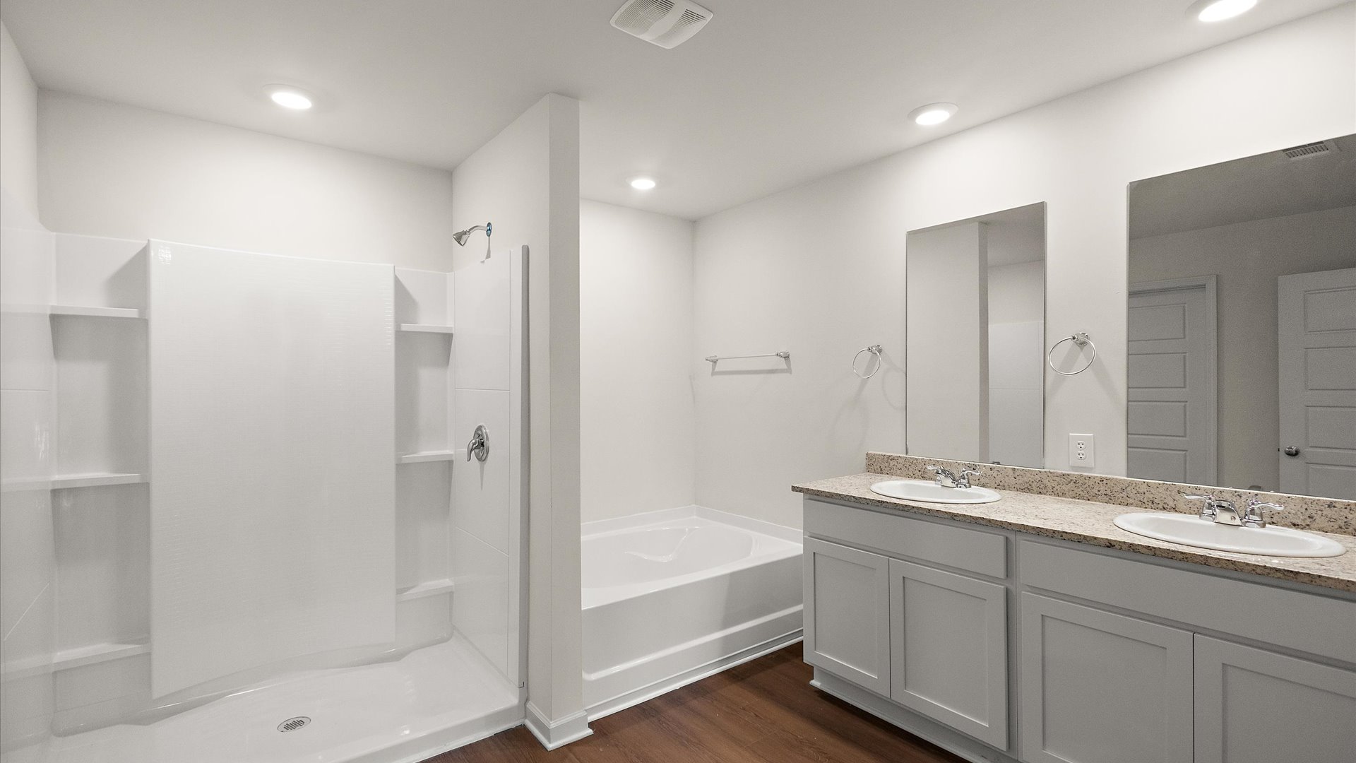 primary bathroom with walk in shoer, garden tub, and dual vanity